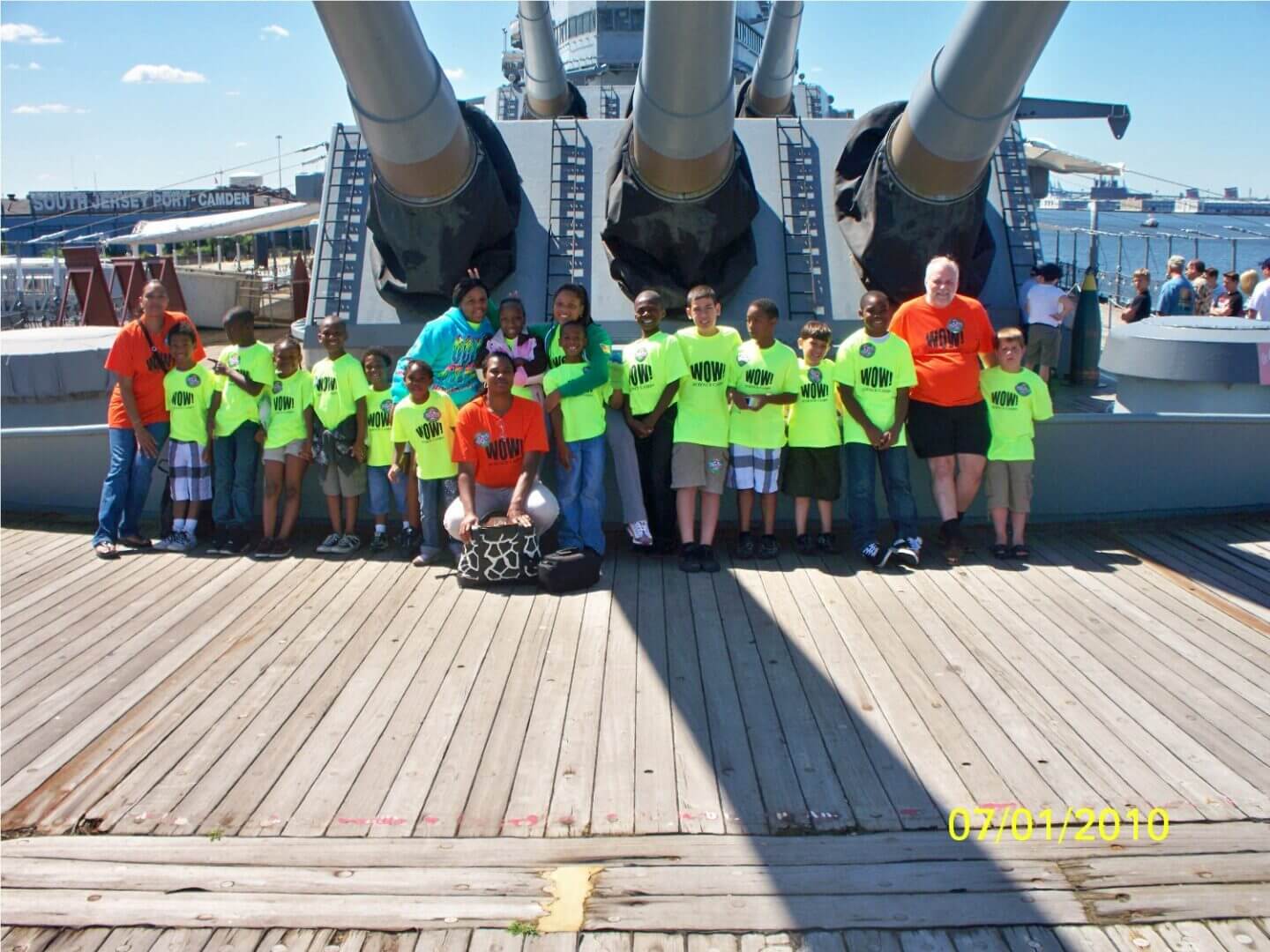 A group of people standing on top of a boat.